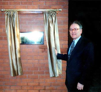 Bill Rosser unveils a plaque at the Rosser building at Sutton High School